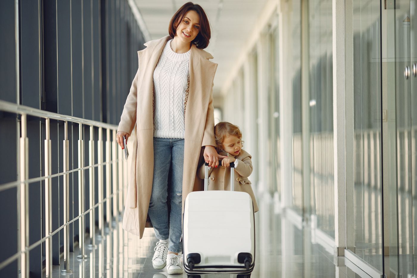 Parent and child walking with a suitcase